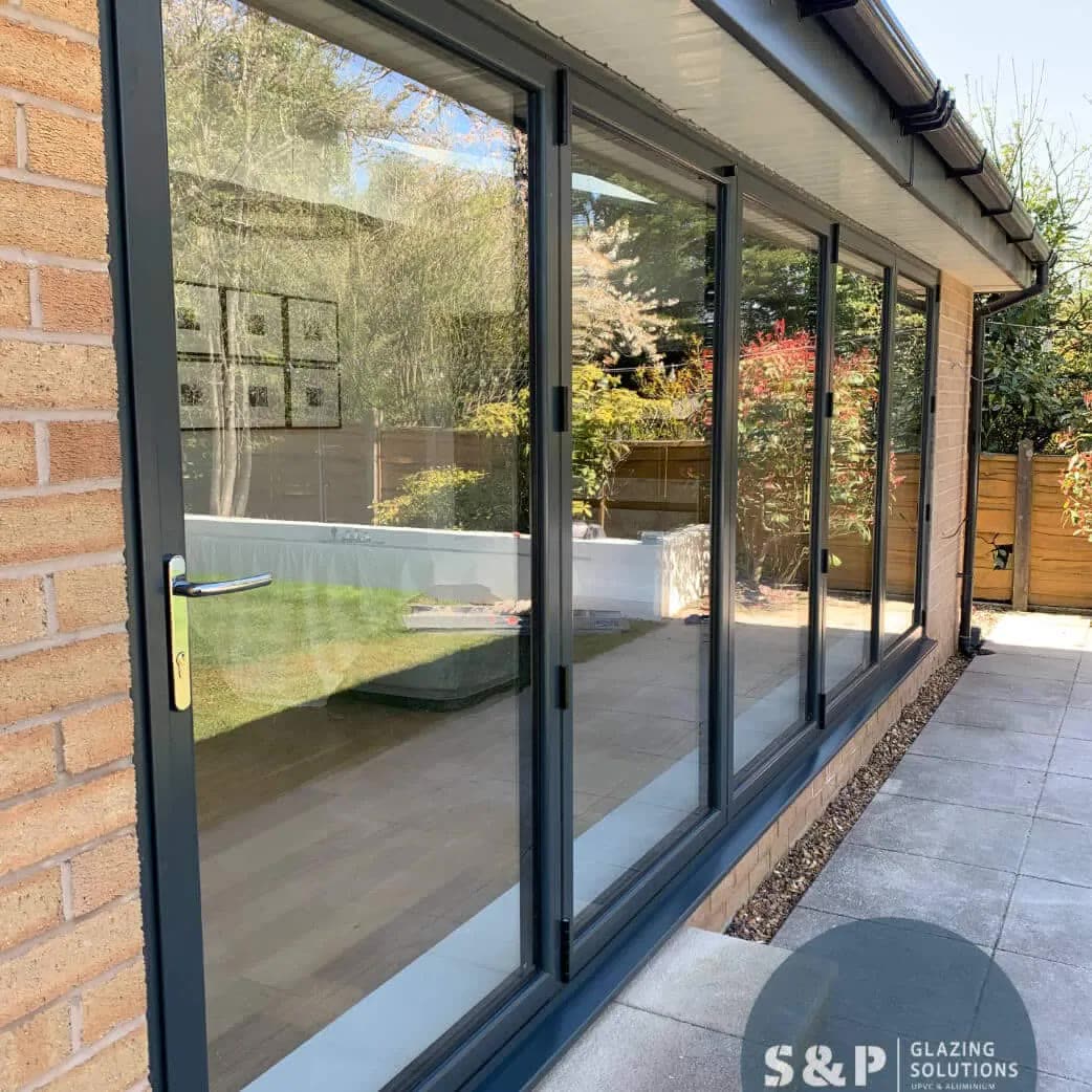Four-panel anthracite bifold doors on a brick rear elevation